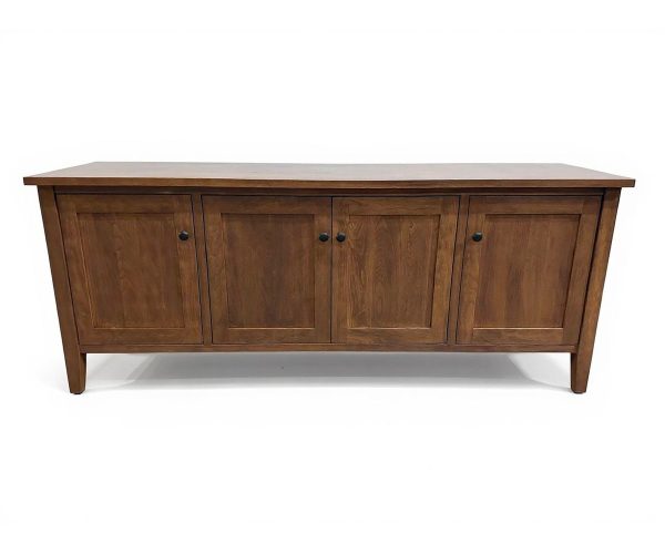 Wooden sideboard with four panel cabinet doors and black knobs on short legs